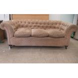 An early 20thC and later upholstered Chesterfield, raised on turned forelegs and casters  74"w