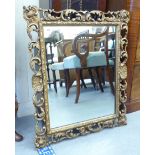 A 20thC mirror, the rectangular plate set in a carved C-scrolled gilt frame  22" x 27"