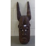 A carved wooden tribal horned mask  38"L