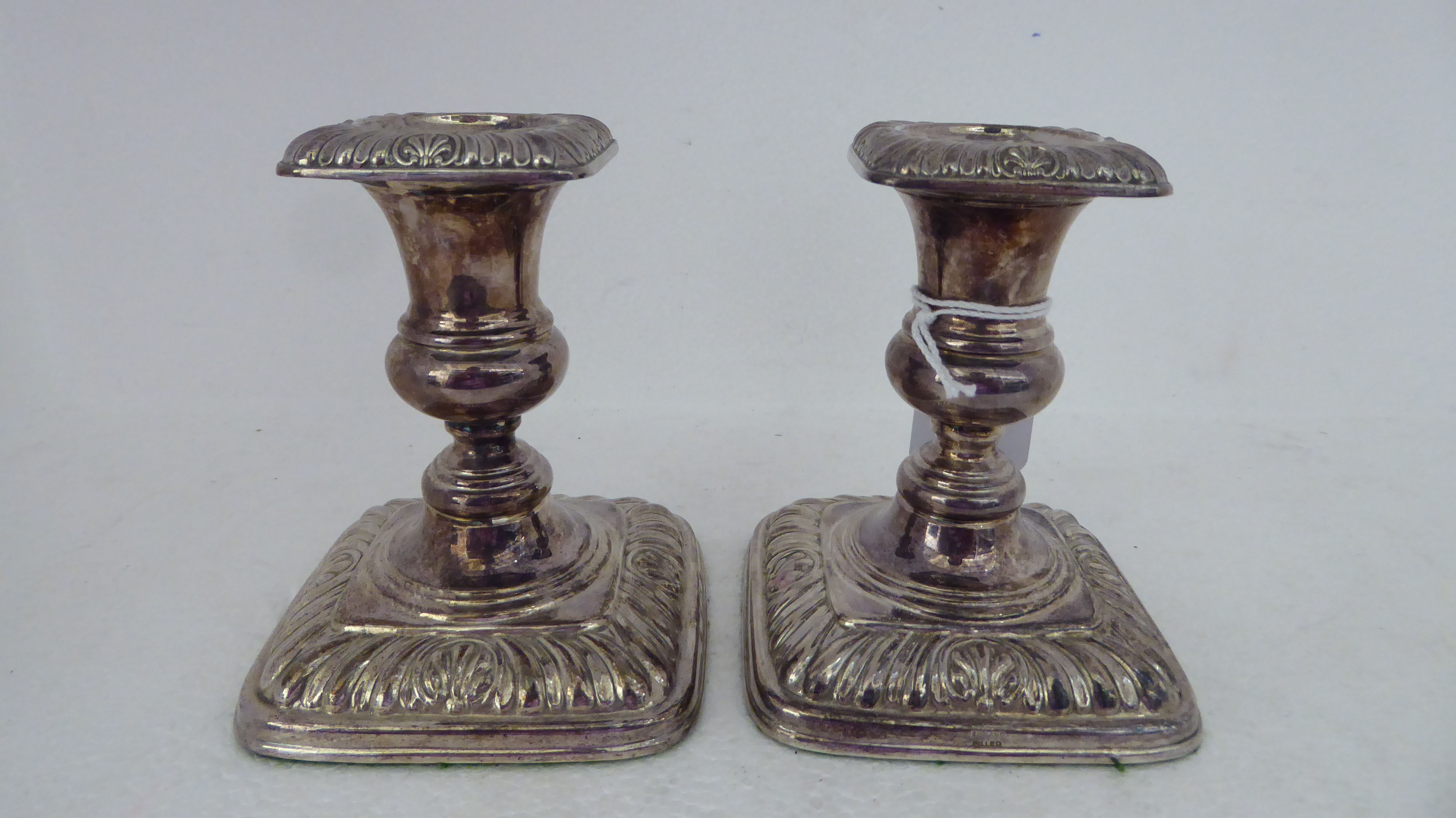 A pair of loaded silver candlesticks with embossed decoration  Birmingham 1987  4.5"h