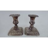 A pair of loaded silver candlesticks with embossed decoration  Birmingham 1987  4.5"h