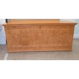 A modern Asian inspired pine blanket chest with straight sides and a hinged lid, over an exotic bird