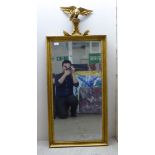 A 20thC reproduction of a Regency mirror, the bevelled plate set in a moulded gilt frame, surmounted