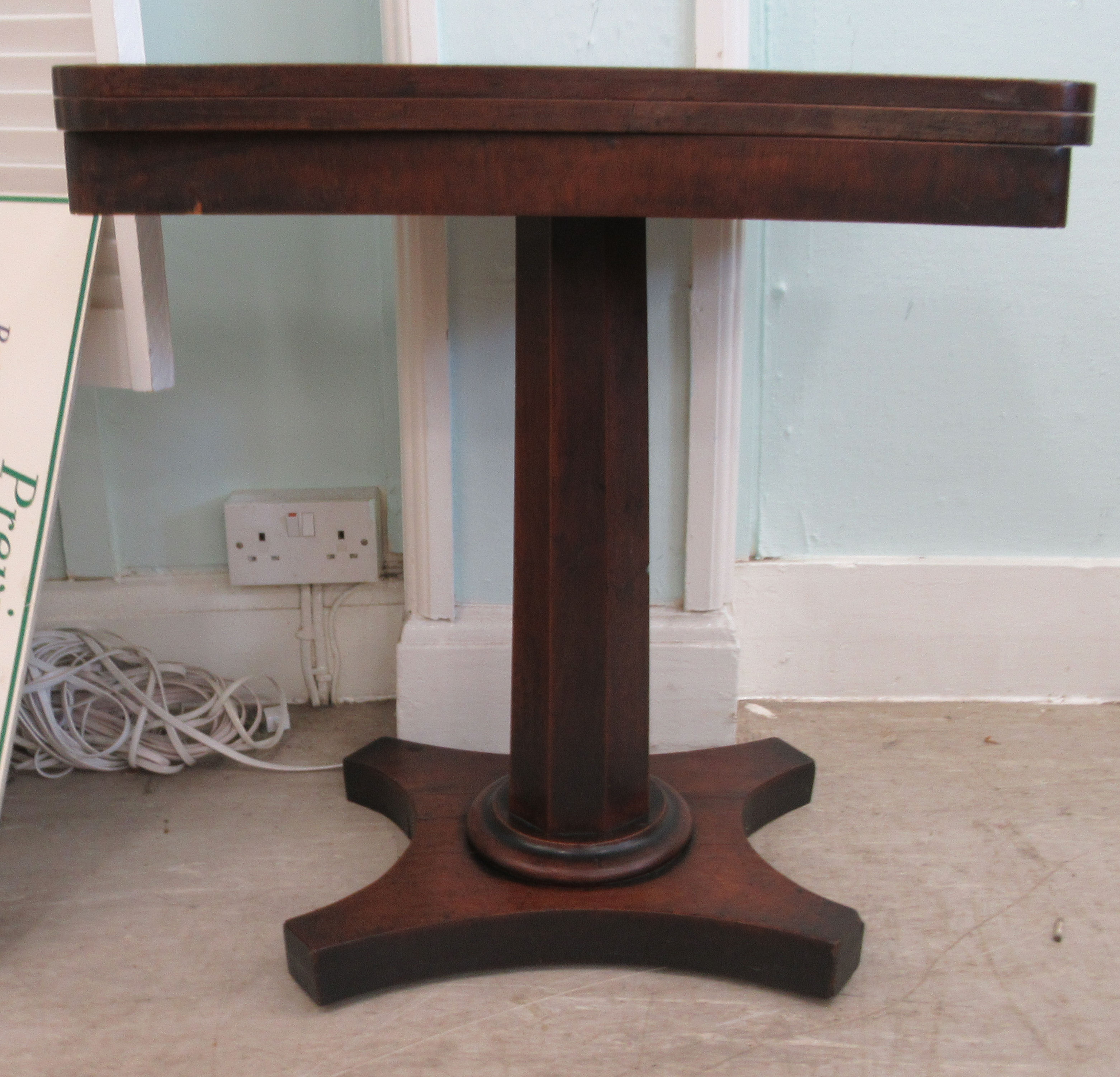 A Regency mahogany pedestal tea table with a rotating foldover top, on a splayed plinth  26"h  25"w