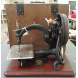 An early 20thC Wilcox & Gibbs manual sewing machine, in a mahogany plinth