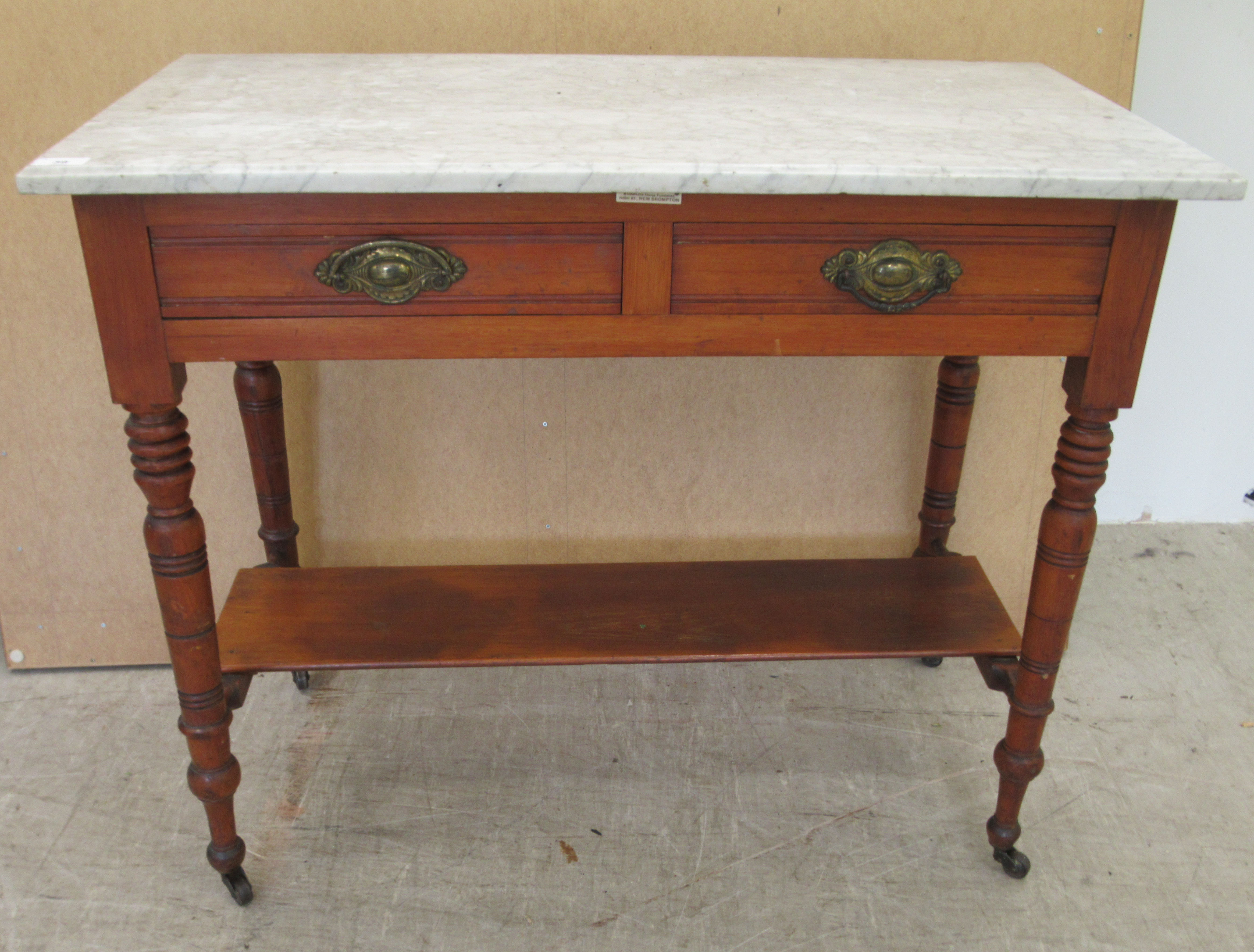 A late Victorian washstand with a marble top, over a mahogany underframe with two frieze drawers,