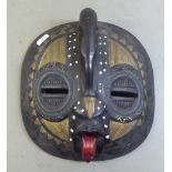 A carved wooden and overpainted mask  15"dia