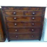 An early Victorian mahogany six drawer dressing chest, on a plinth and turned feet  48"h  48"w