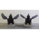 A pair of cast iron models, a winged exotic bird of prey, on a marble plinth  10"L overall with a