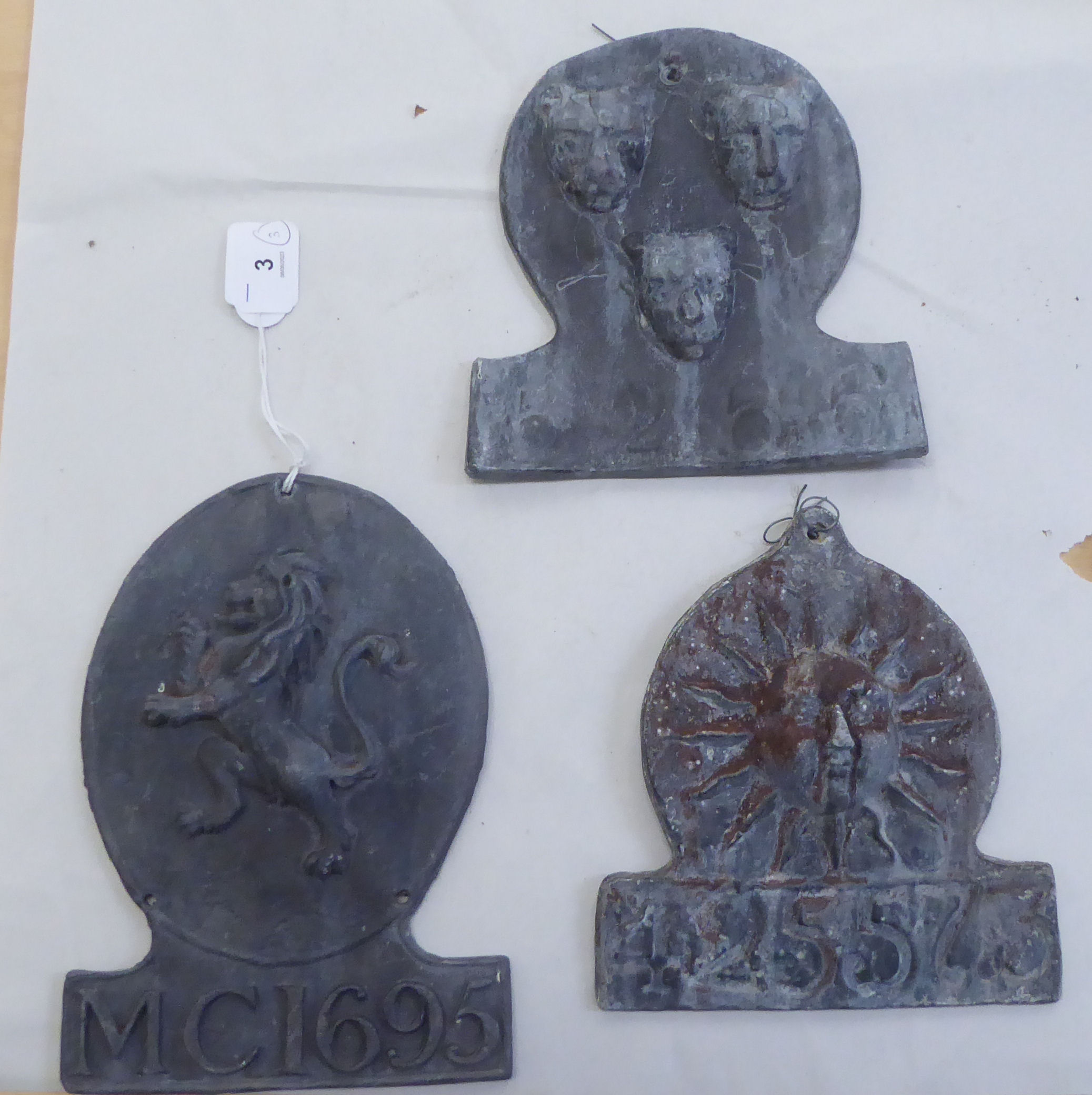 Three 19thC style lead fire marks, each with an individual ornament and a serial number