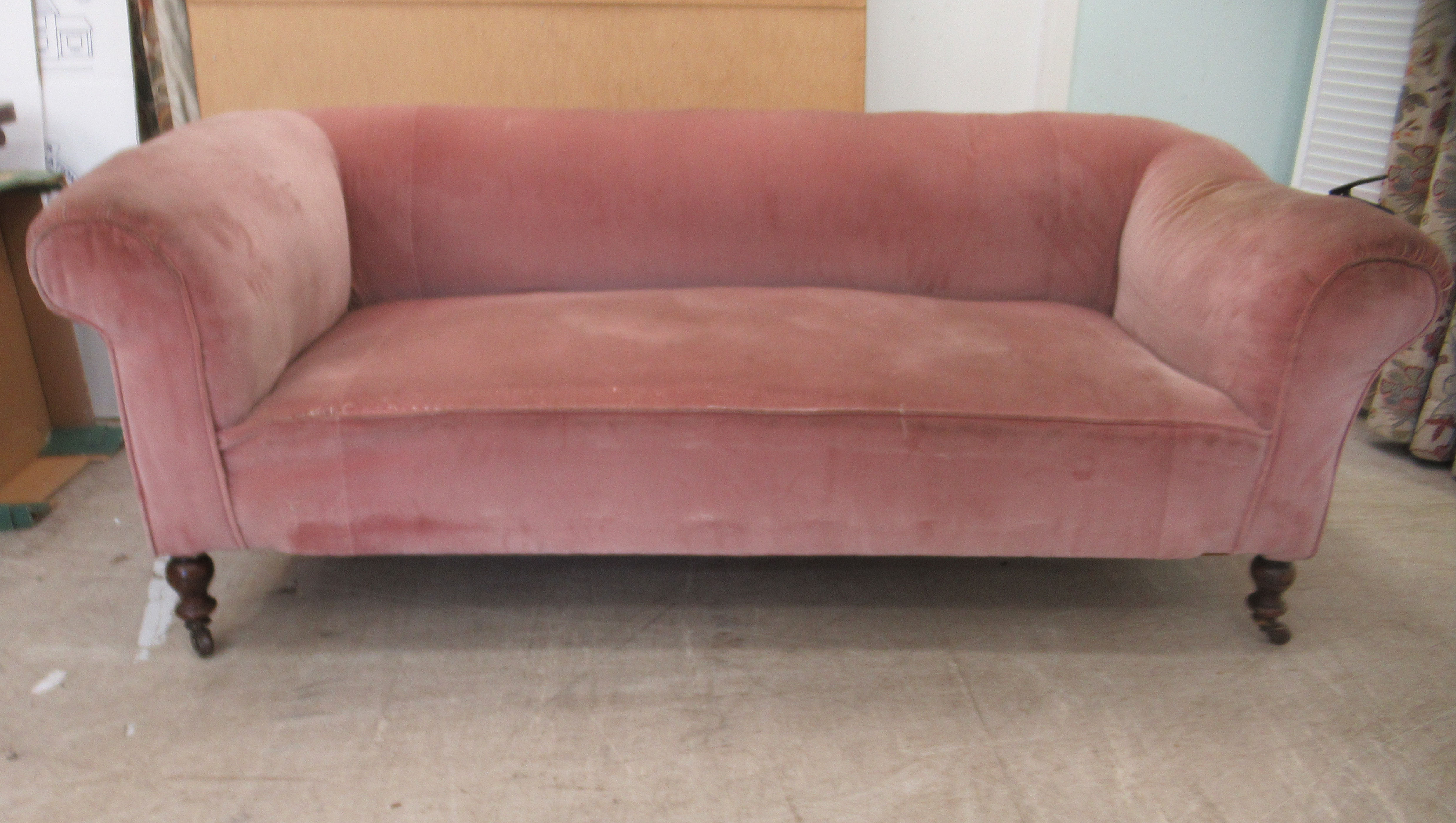 An Edwardian and later upholstered Chesterfield, raised on ring turned forelegs and casters  74"w,