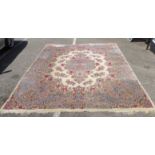 A Persian carpet, decorated with flora and foliage designs, on a cream coloured ground  106" x 136"