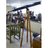 A 20thC black painted metal and lacquered brass telescope  12"L, on a tripod stand