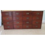 An early 20thC Chinese stained pine sixteen drawer cabinet, on a plinth  30"h  63"w