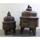Two Asian cast metal hinged food containers, on tripod bases  21"h & 15"h