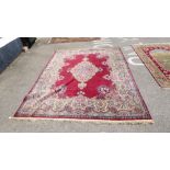 A Persian carpet, decorated with a central serpentine outlined medallion, bordered by C-scrolled and