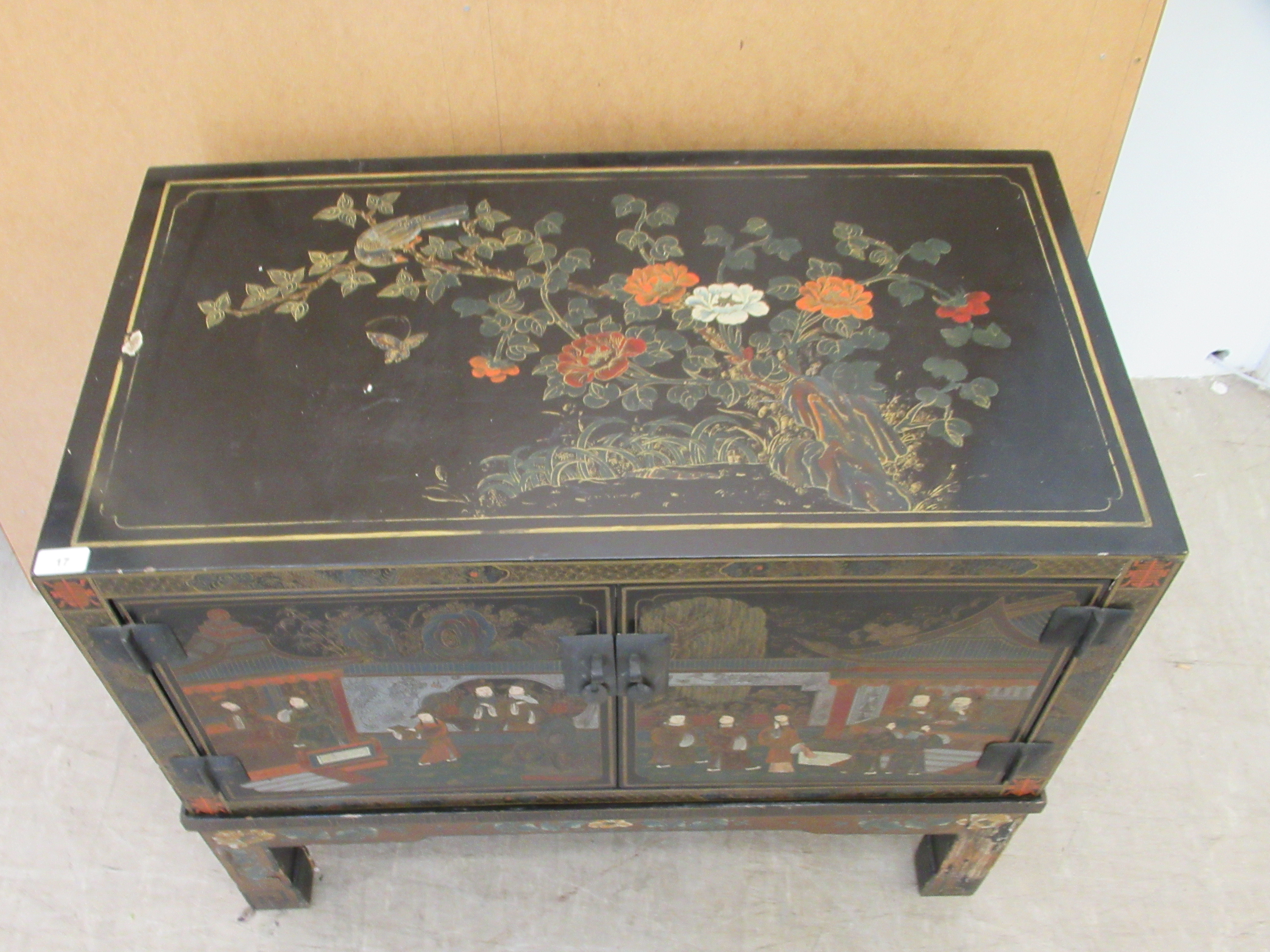 A 20thC Japanese black lacquered low cabinet on stand with two doors, decorated with traditional - Image 2 of 6