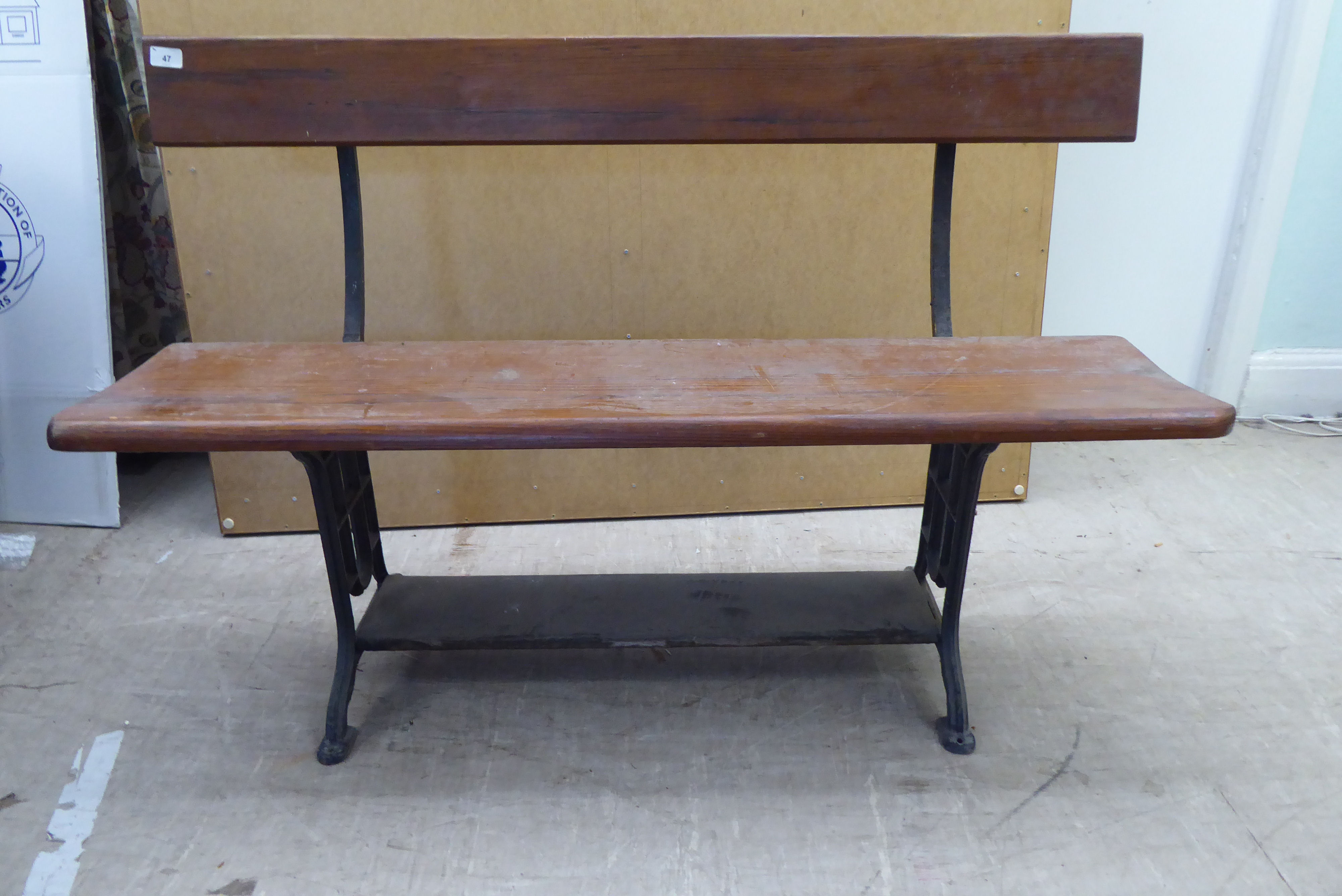 An early 20thC cast iron and planked pine framed two person terrace bench  48"w