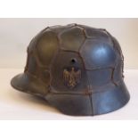 A World War II German Army steel helmet with a hide liner and chinstrap, two decals and clad in