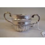 An 18thC style Britannia silver porringer with a flared lip, S-shape handle, embossed demi-reeded,