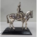 An early 20thC white metal figure, a uniformed and mounted Household Cavalryman  5.5"h on a black