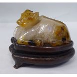 A Chinese agate model, a resting buffalo  2"h on a carved hardwood stand