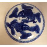 A Chinese porcelain disc shape, two part ink pot, decorated in blue and white with fish, bears a