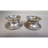 A pair of loaded silver dwarf candleholders  PS  London 2003