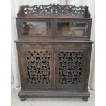 A late Victorian Anglo-Indian, profusely carved and stained oak cabinet, the galleried upper part