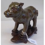 A Chinese mottled green glazed pottery model, a standing porcine creature  5.5"h on a carved