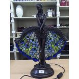 An Art Deco inspired bronze effect table lamp, fashioned as a dancer holding lead glazed peacock