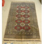 A Turkoman rug, decorated with repeating diamond formation, bordered by stylised designs, on a