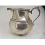 A silver cream jug of bulbous octagonal form with a S-scrolled handle  London 1924