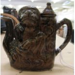 A treacle glazed stoneware novelty miniature teapot, fashioned as a seated monkey