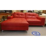 A modern two part corner settee, upholstered in stitched red hide, raised on metal peg feet  65"deep