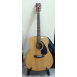 A Yamaha model no. F310 acoustic guitar  cased with a stand
