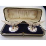 A pair of Edwardian loaded silver and carved mother-of-pearl knife rests, in the form of angels with