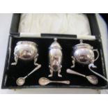 A three piece silver bulbous shaped condiments set with cast Celtic border ornament  comprising a