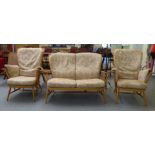 An Ercol blonde beech framed high hoop and spindled back settee with enclosed arms and fitted,