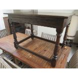 A George III rustic  oak kitchen table, raised on turned, block legs, united by stretchers  28"h