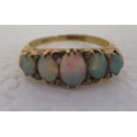 An 18ct gold ring set with five graduated opals and small diamonds