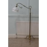 A mid 20thC lacquered brass standard lamp with a C-scrolled arm, on a splayed tripod base  55"h