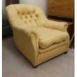 An early 20thC and later gold floral patterned fabric, upholstered low, enclosed armchair, raised on