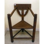 A mid 20thC oak and pine panelled turners chair with irregularly carved ornament