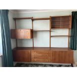 A vintage PS System teak wall unit, comprising an arrangement of open and enclosed shelves, a