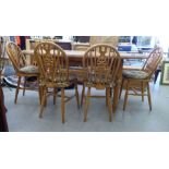 A modern waxed pine oval dining table, raised on baluster and block legs  31"h  53"L extending to