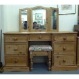 A modern waxed pine, inverted breakfront, five drawer twin pedestal dressing table, surmounted by