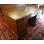 A mid 20thC mahogany finished partners desk, the top set with a tooled and gilded brown hide scriber