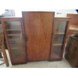 An Art Deco mahogany breakfront bookcase with a stepped top, over a central, full height door and