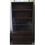 A 1960s/1970s rosewood two part living room unit, the upper section comprising two open shelves